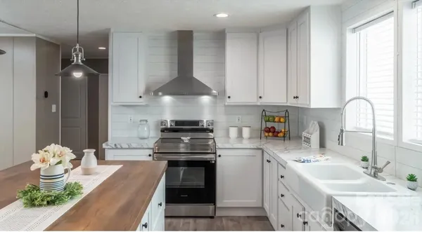 a kitchen with stainless steel appliances a stove a sink and a refrigerator