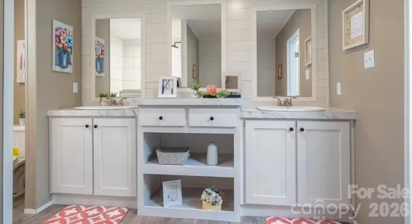 a spacious bathroom with a granite countertop double vanity sink and a mirror