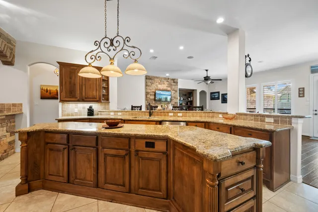 a kitchen with granite countertop a stove and a wooden cabinets