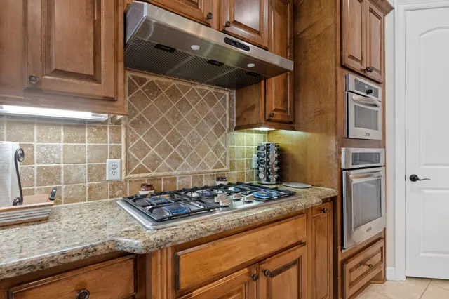 a kitchen with granite countertop a stove and a wooden cabinets