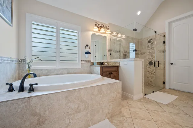 a bathroom with a granite countertop sink a mirror and shower