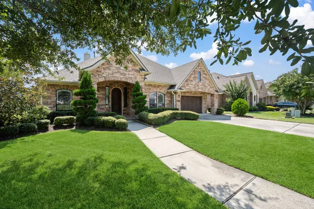 a front view of a house with a garden and plants