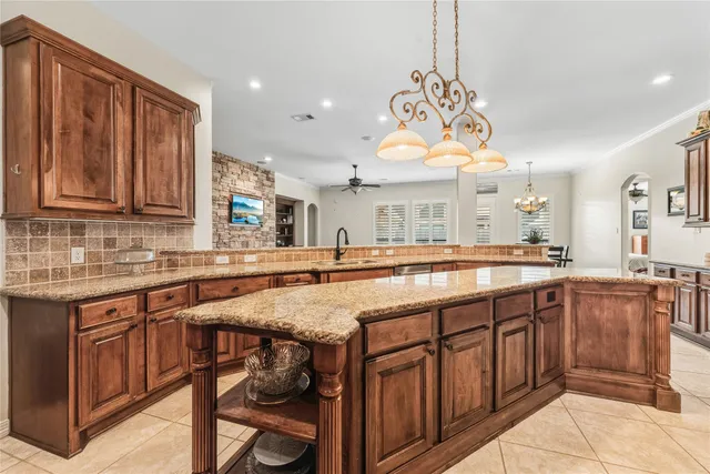 a kitchen with granite countertop a stove and a wooden cabinets