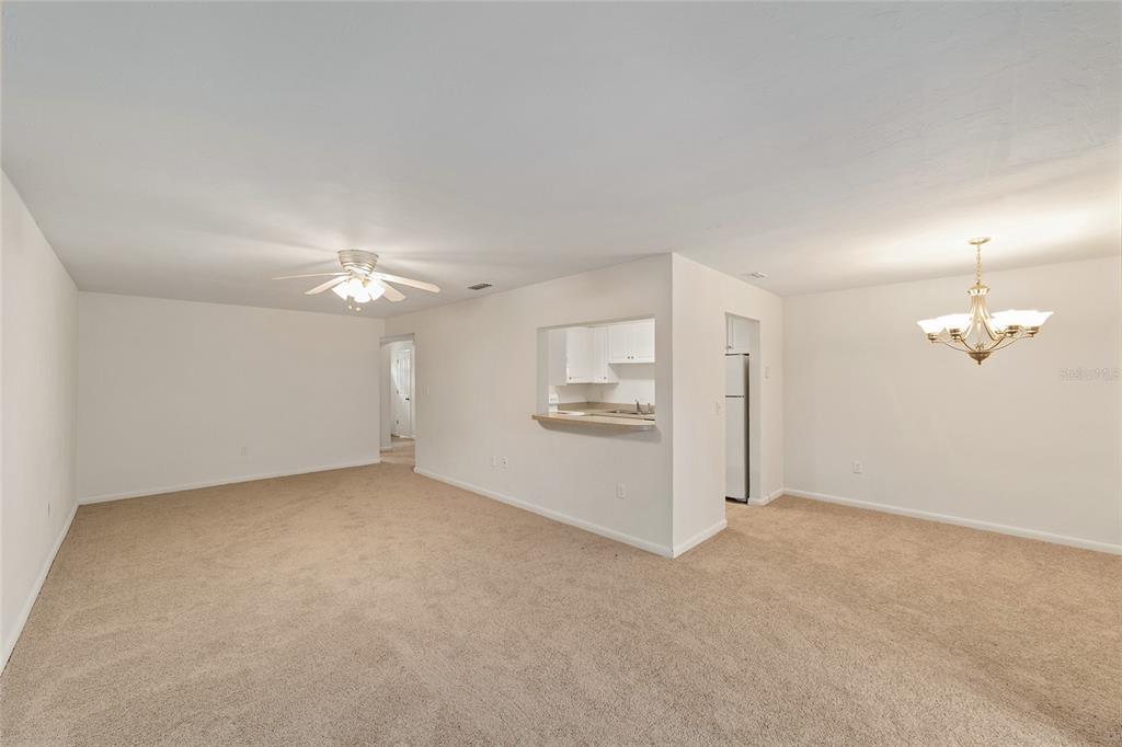 501 Southwest 75th Street, Unit H6 Gainesville, FL 32607 - Photo 22 of 42 an empty room with chandelier fan and windows