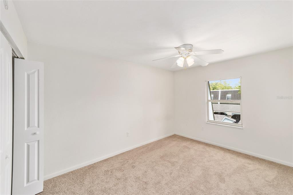 501 Southwest 75th Street, Unit H6 Gainesville, FL 32607 - Photo 23 of 42 an empty room with a window and a ceiling fan