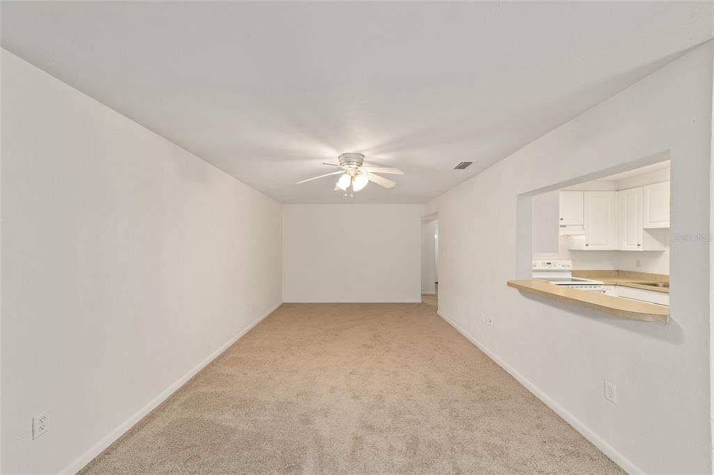 501 Southwest 75th Street, Unit H6 Gainesville, FL 32607 - Photo 7 of 42 an empty room with chandelier fan and windows
