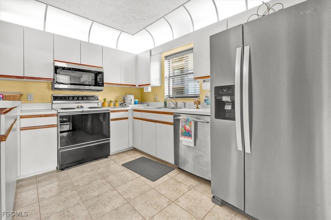 707 Hoover Dike Road, Unit 904 Clewiston, FL 33440 - Photo 11 of 38 a kitchen with stainless steel appliances granite countertop a stove top oven and refrigerator