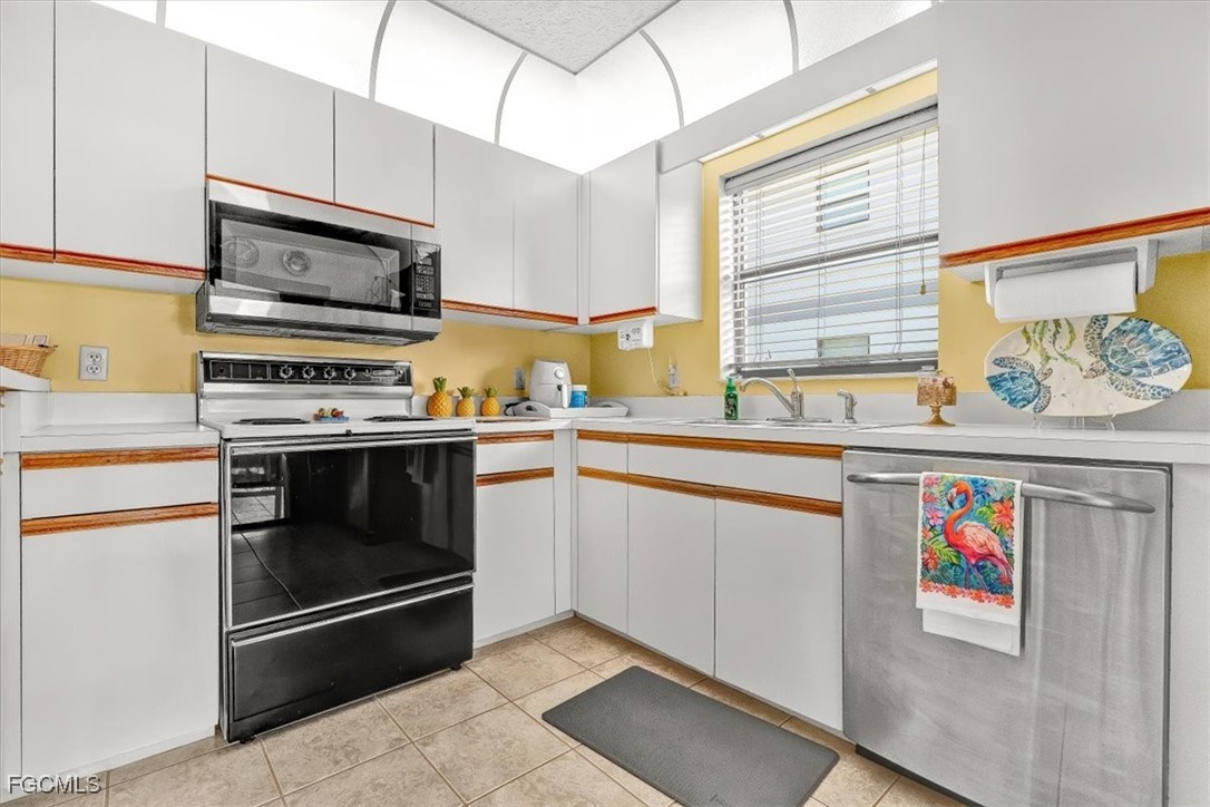 707 Hoover Dike Road, Unit 904 Clewiston, FL 33440 - Photo 12 of 38 a kitchen with stainless steel appliances a stove a microwave and sink
