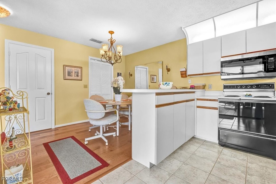707 Hoover Dike Road, Unit 904 Clewiston, FL 33440 - Photo 14 of 38 a kitchen with a sink a stove and chairs