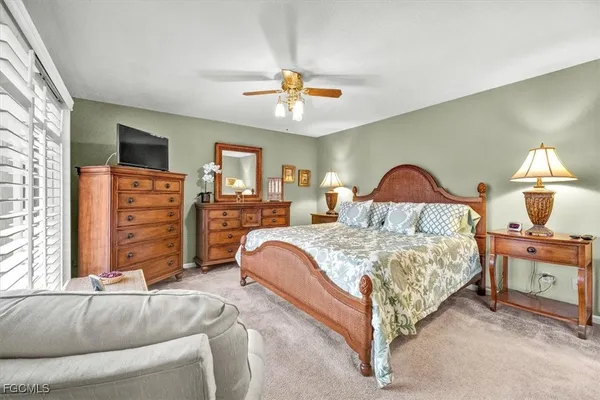 a bedroom with a bed and a chandelier with a flat tv screen