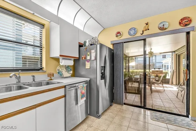 a kitchen with stainless steel appliances granite countertop a sink and a refrigerator