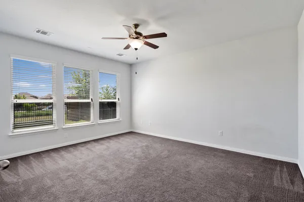 an empty room with closet and windows