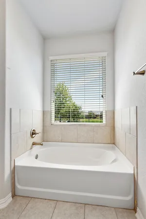 an empty room with wooden floor ceiling fan and windows
