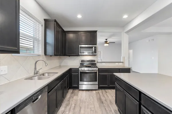a kitchen with stainless steel appliances granite countertop a sink stove and refrigerator