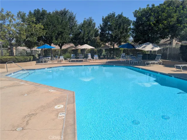 a view of a swimming pool with outdoor seating and plants