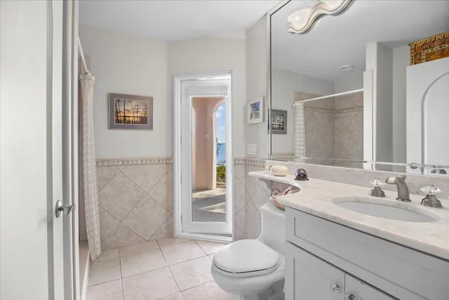 a bathroom with a granite countertop sink a toilet and shower