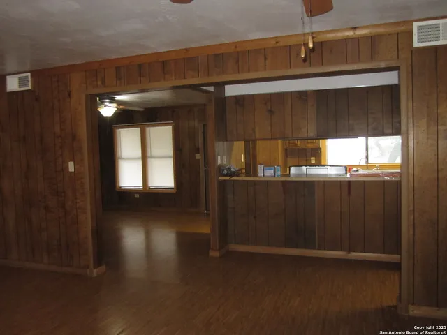 a view of a hallway with wooden floor and a window