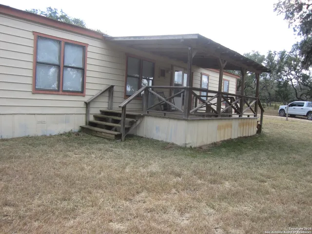 a view of house with outdoor seating and covered with trees