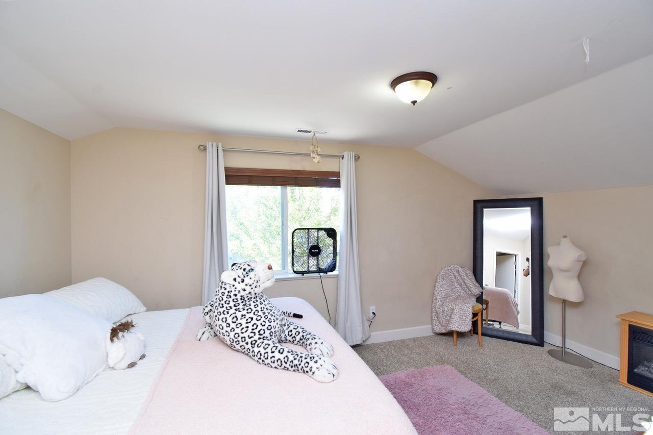 2735 Gulling Court Reno, NV 89503 - Photo 21 of 30 a bedroom with a large bed and a chandelier
