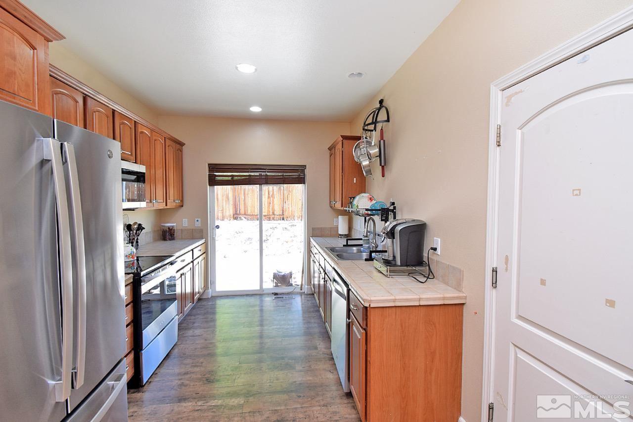 2735 Gulling Court Reno, NV 89503 - Photo 3 of 30 a kitchen with stainless steel appliances granite countertop a refrigerator a stove and a sink with wooden floor