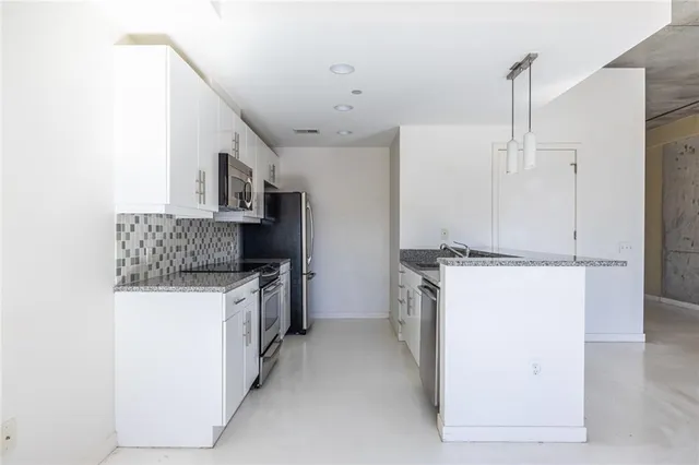 a kitchen with a stove a refrigerator and a sink