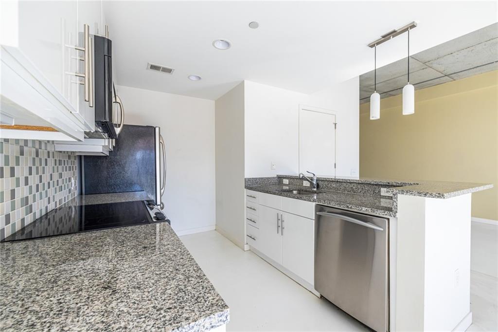 335 West Ponce De Leon Avenue, Unit 506 Decatur, GA 30030 - Photo 19 of 49 a kitchen with stainless steel appliances granite countertop a sink and a refrigerator