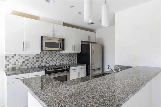 a kitchen with stainless steel appliances granite countertop a sink stove and refrigerator