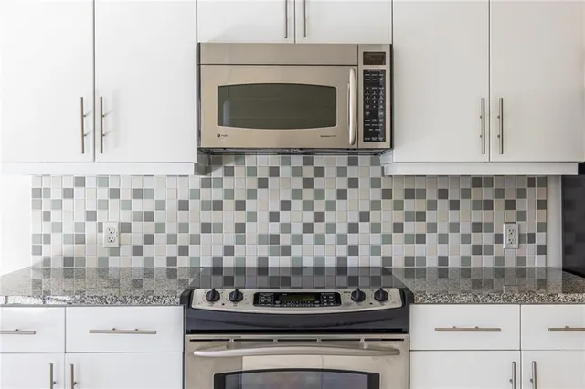 a kitchen with granite countertop a stove and a microwave