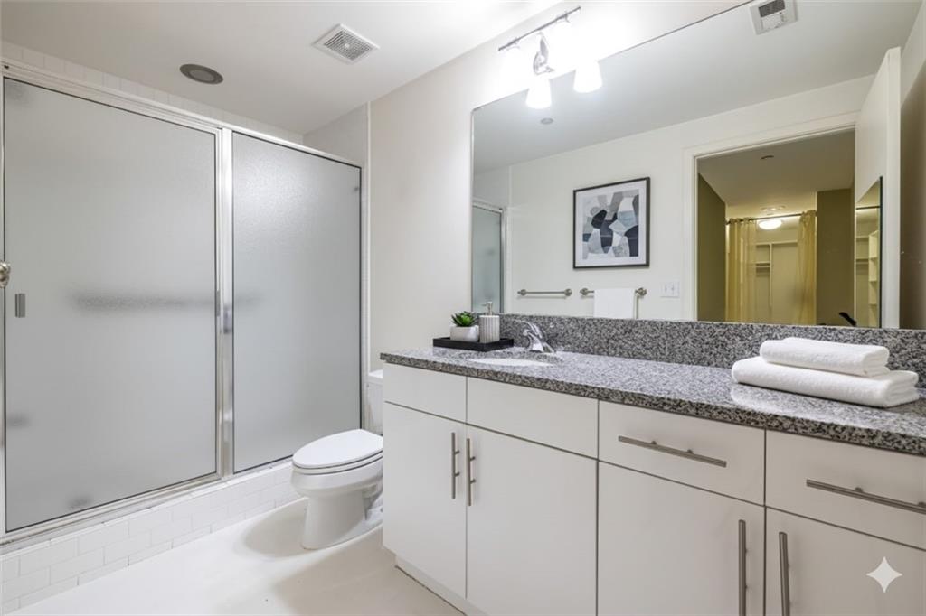 335 West Ponce De Leon Avenue, Unit 506 Decatur, GA 30030 - Photo 34 of 49 a bathroom with a granite countertop sink a toilet and a mirror