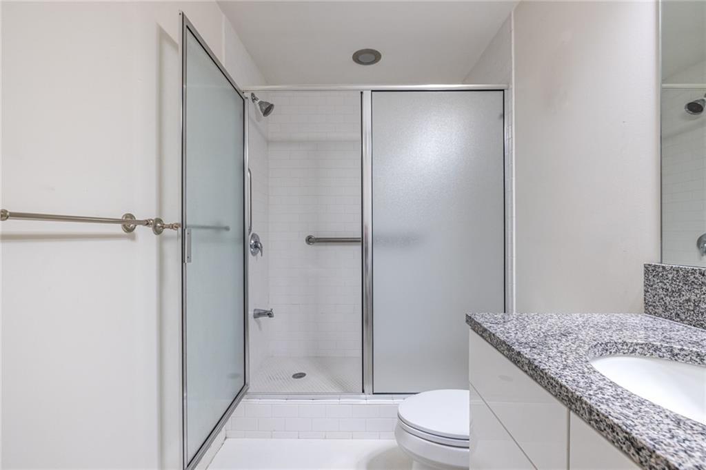 335 West Ponce De Leon Avenue, Unit 506 Decatur, GA 30030 - Photo 36 of 49 a bathroom with a granite countertop sink toilet and shower