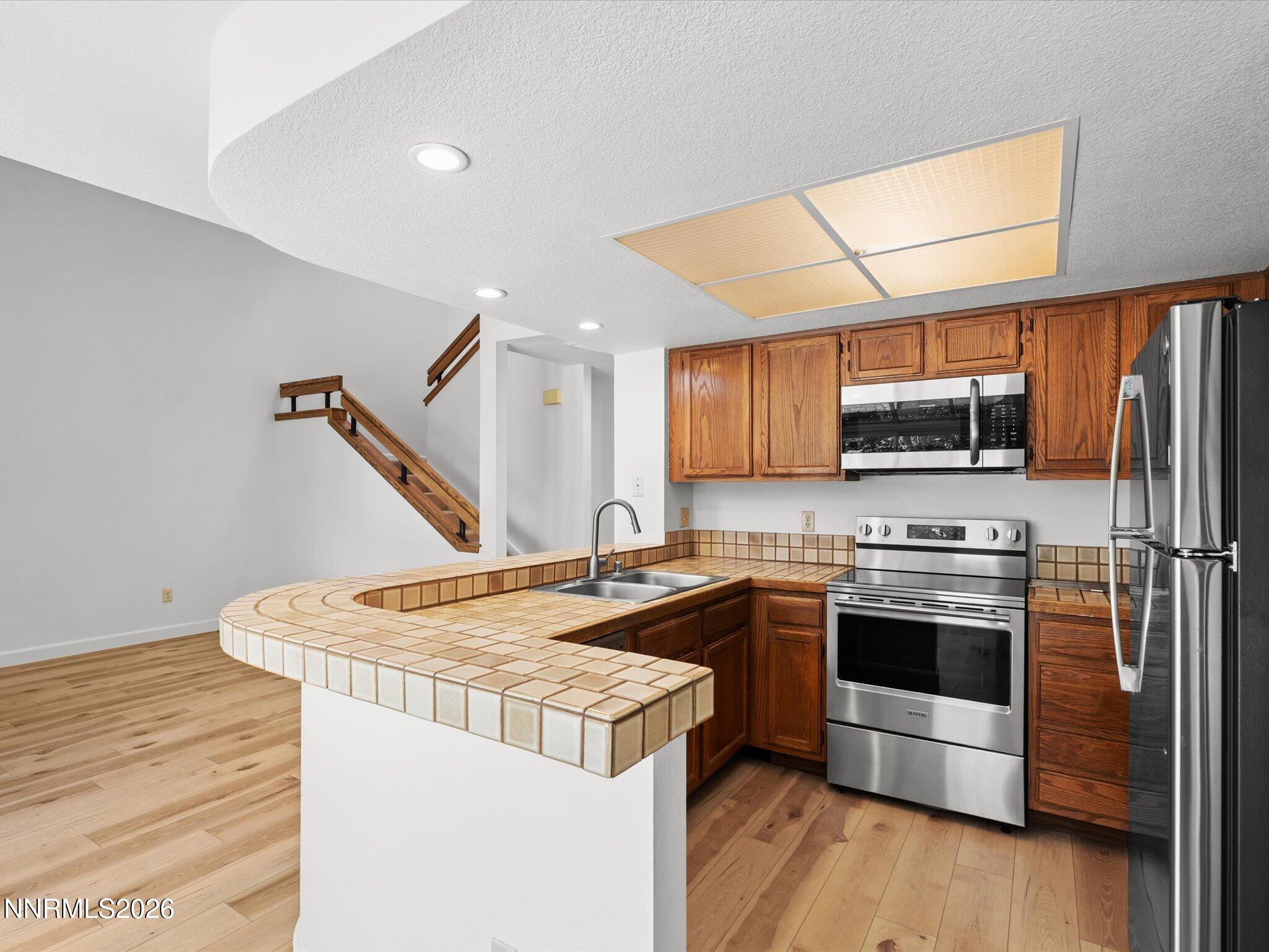 3170 Oakshire Court Reno, NV 89509 - Photo 19 of 43 a kitchen with stainless steel appliances a stove a sink and a microwave