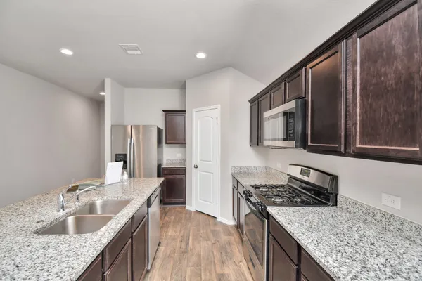 a kitchen with stainless steel appliances granite countertop a sink stove and refrigerator