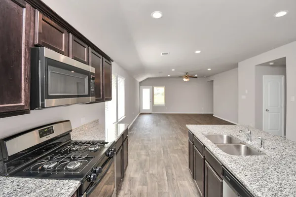 a kitchen with stainless steel appliances granite countertop a sink stove and cabinets