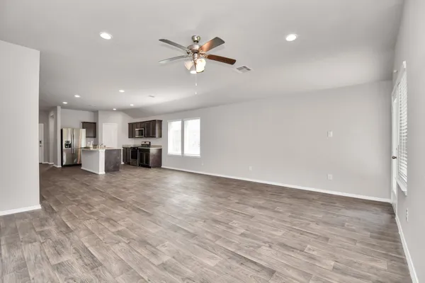 a view of empty room with wooden floor and window