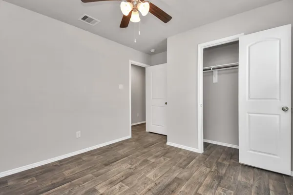a view of an empty room with wooden floor