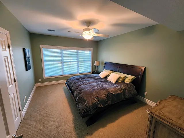 a bedroom with a bed and a large window