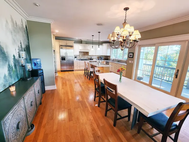 a view of a dining room with furniture a chandelier and wooden floor