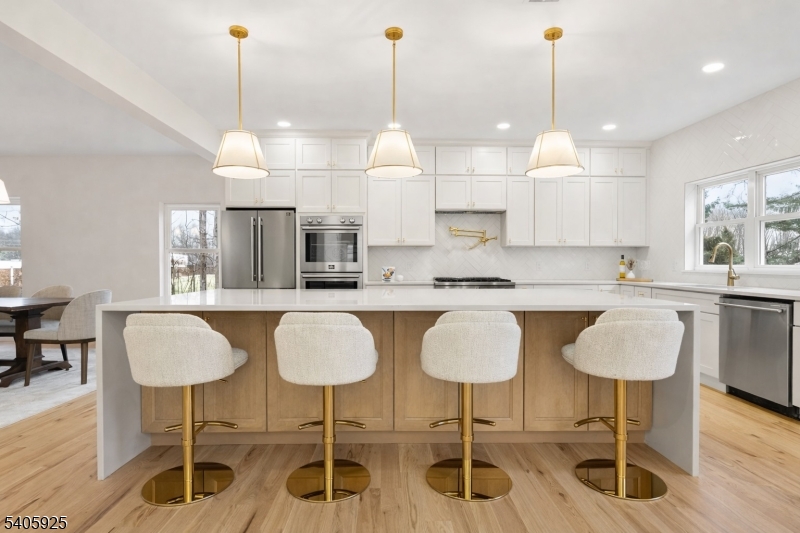 100 Louis Street Whippany, NJ 07981 - Photo 13 of 47 a kitchen with stainless steel appliances granite countertop a dining table chairs and white cabinets