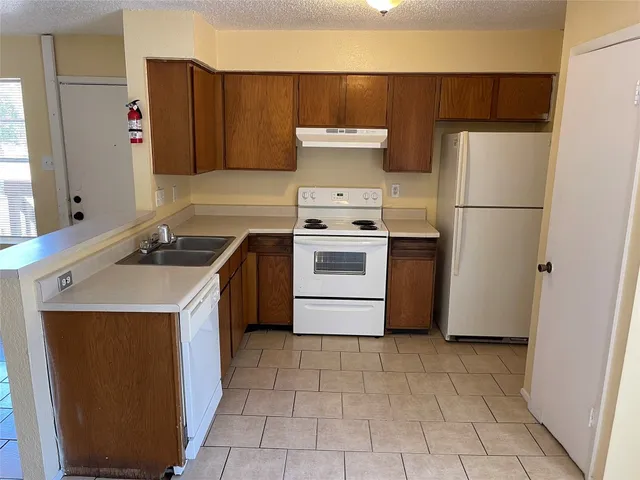 a kitchen with a stove sink and refrigerator
