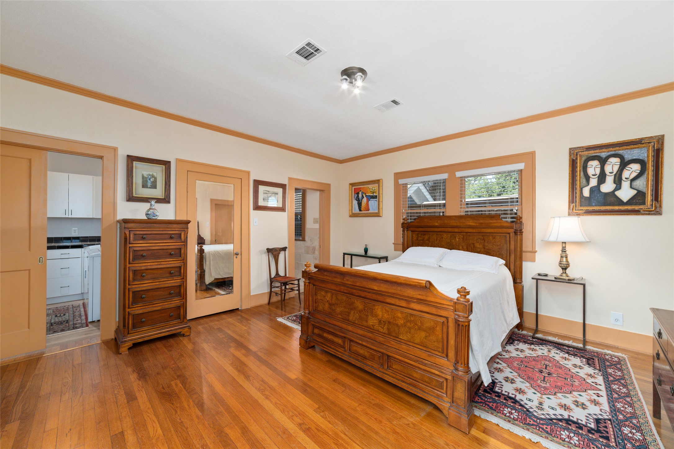 1613 California Street Houston, TX 77006 - Photo 28 of 50 The primary suite is a peaceful retreat where generous proportions, warm hardwood floors, and windows overlooking the private grounds create a setting that feels both timeless and serene. Thoughtfully connected to the spa-inspired bath, laundry room, and sunlit gallery beyond.