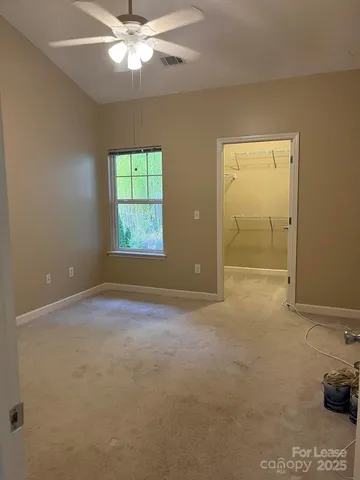 en empty room with windows and ceiling fan