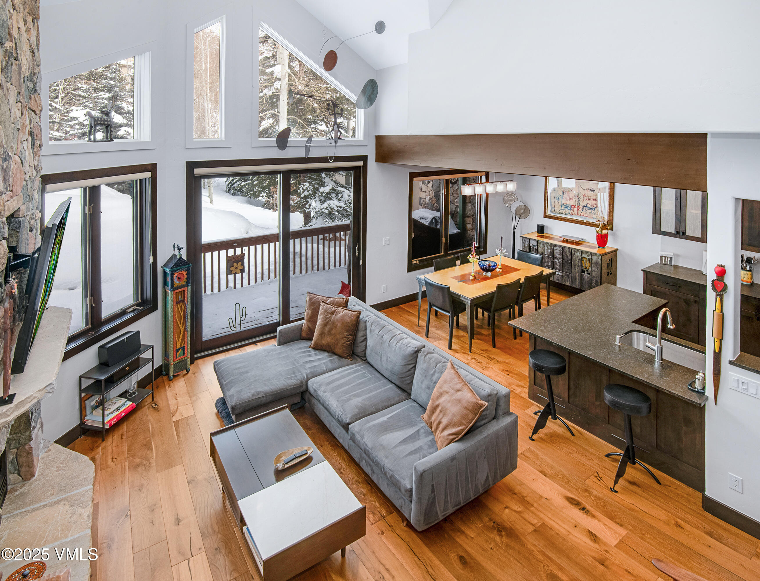 a living room with furniture a large window and wooden floor