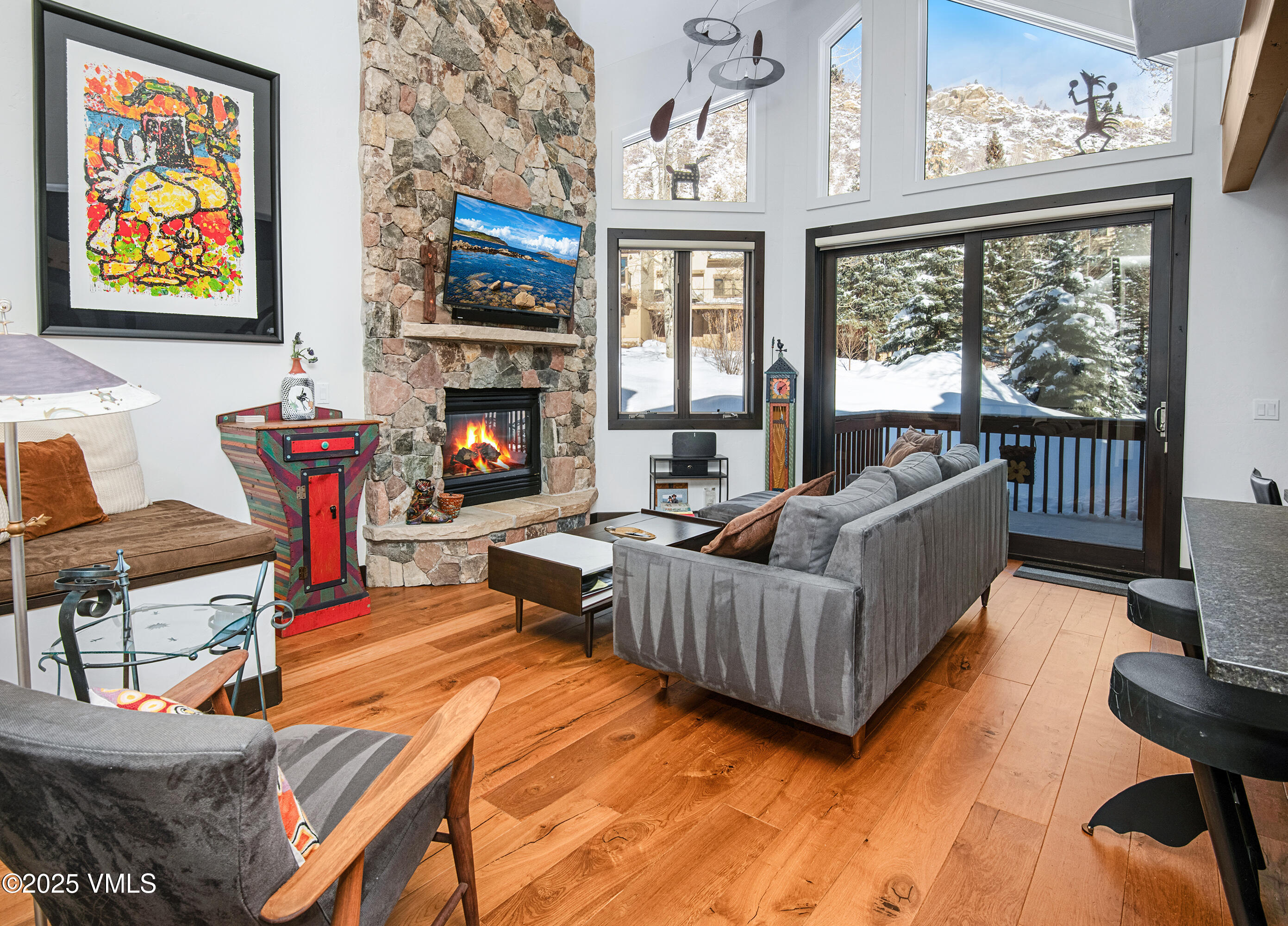 1890 Lions Ridge Loop, Unit 8 Vail, CO 81657 - Photo 2 of 39 a living room with furniture a fireplace and a large window