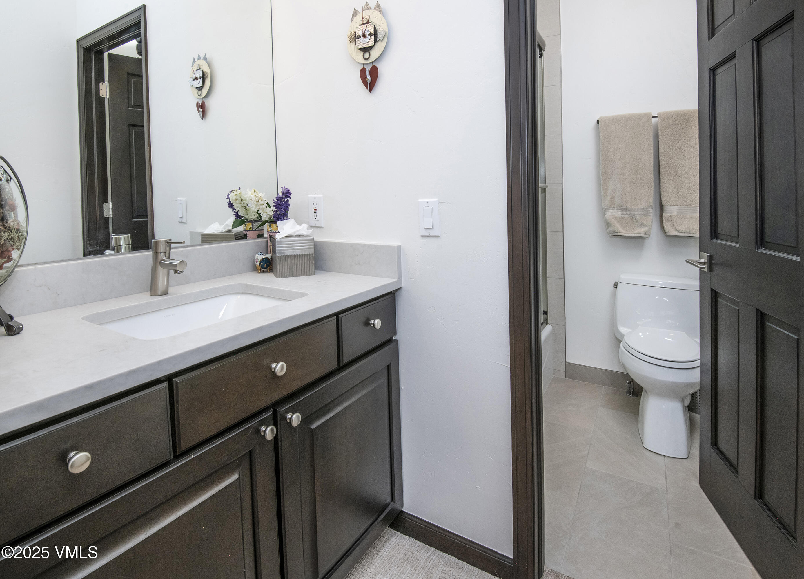 1890 Lions Ridge Loop, Unit 8 Vail, CO 81657 - Photo 23 of 39 a bathroom with a granite countertop sink a toilet a mirror and shower