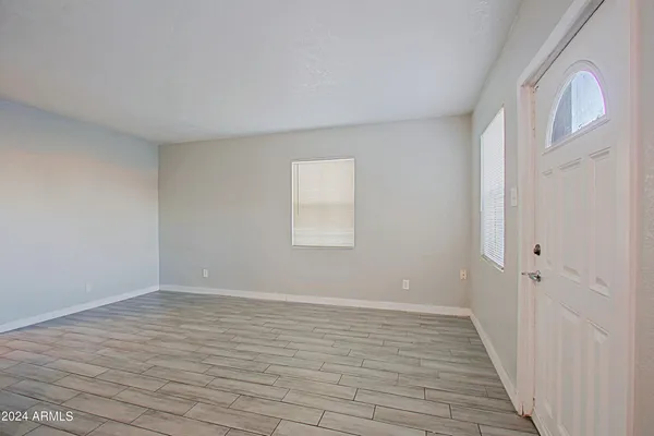 a big room with wooden floor and windows