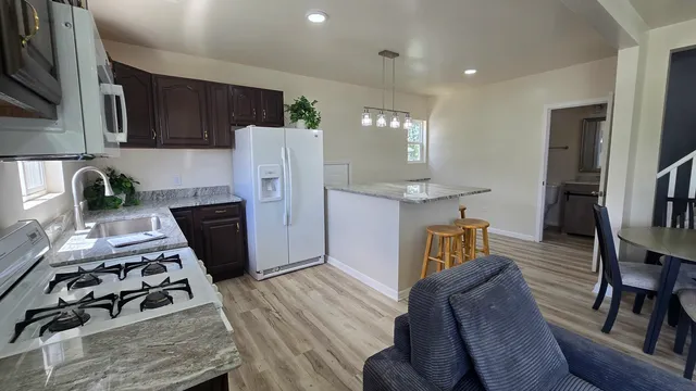 a kitchen with stainless steel appliances granite countertop a stove refrigerator and a stove