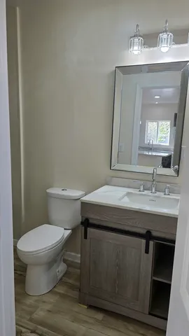 a bathroom with a toilet a sink and mirror