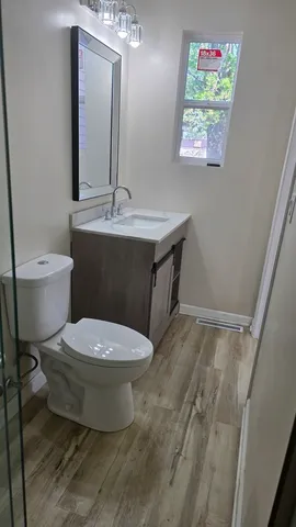 a bathroom with a toilet a sink and mirror