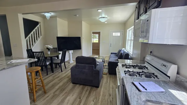a living room with furniture a wooden floor and a flat screen tv