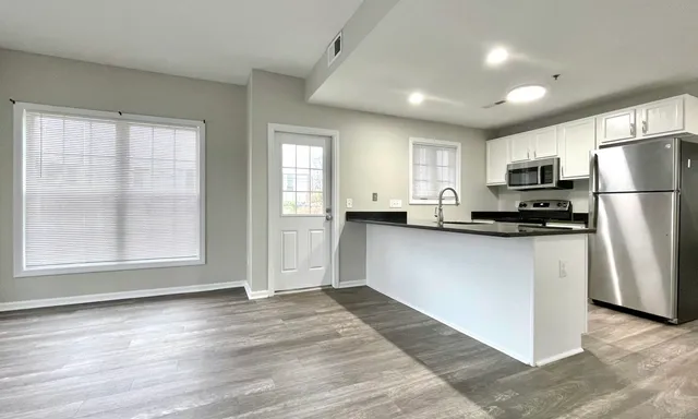 a kitchen with refrigerator a microwave and white cabinets